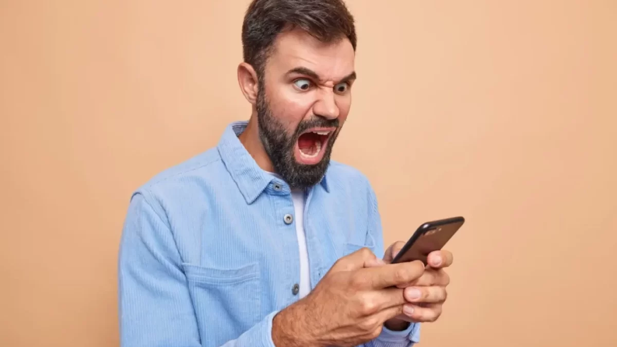 Rozzlobený muž s telefonem v ruce