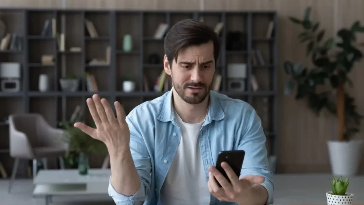 Muž se diví u mobilního telefonu