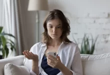 Divící se žena nad mobilním telefonem