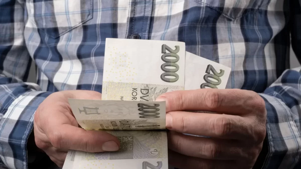 Muž počítající české peníze