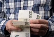Muž počítající české peníze