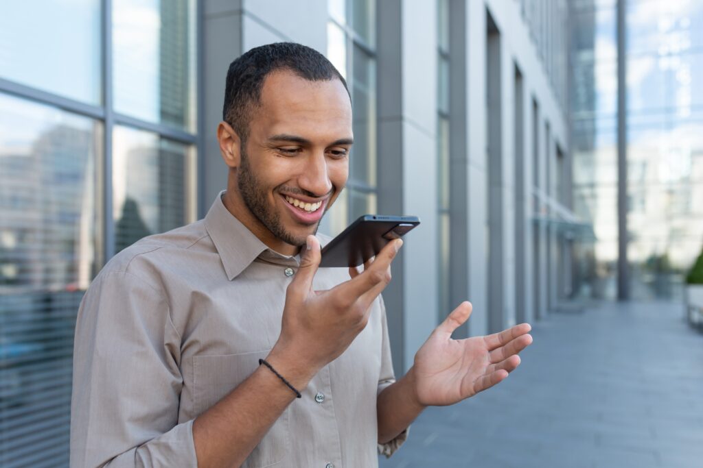 Pozor byste měli dávat hlavně při odemykání telefonu hlasem na veřejnosti, Zdroj: Shutterstock.com - ByznysDeník Muž mluví do telefonu a usmívá se