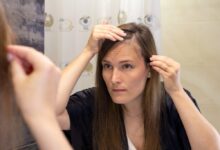 Žena v zrcadle prohlíží své řídnoucí vlasy