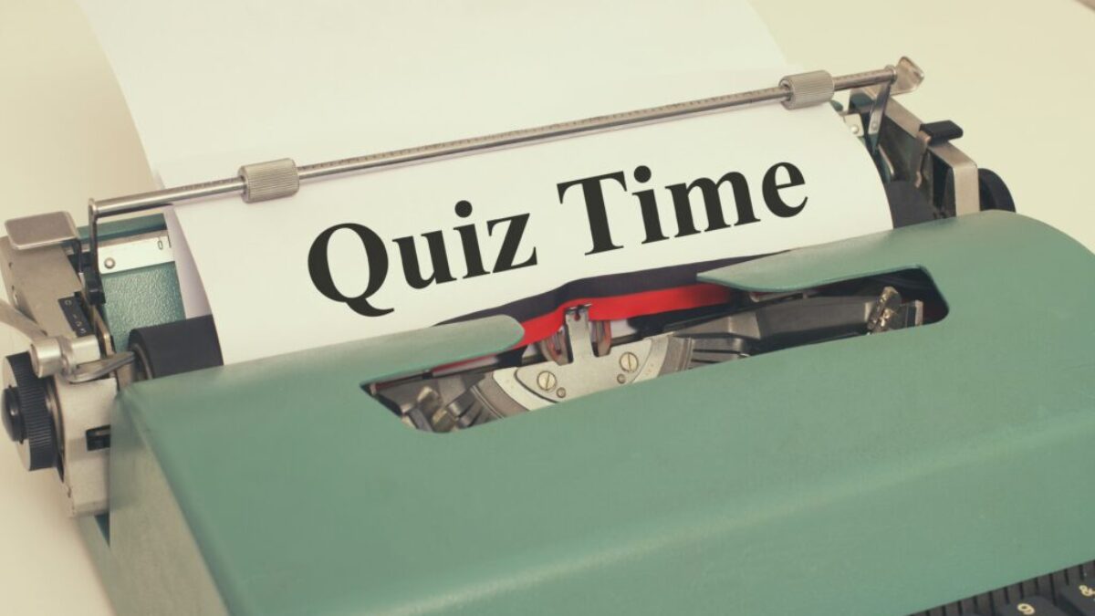 Starý psací stroj, ve kterém je papír s nápisem quiz time