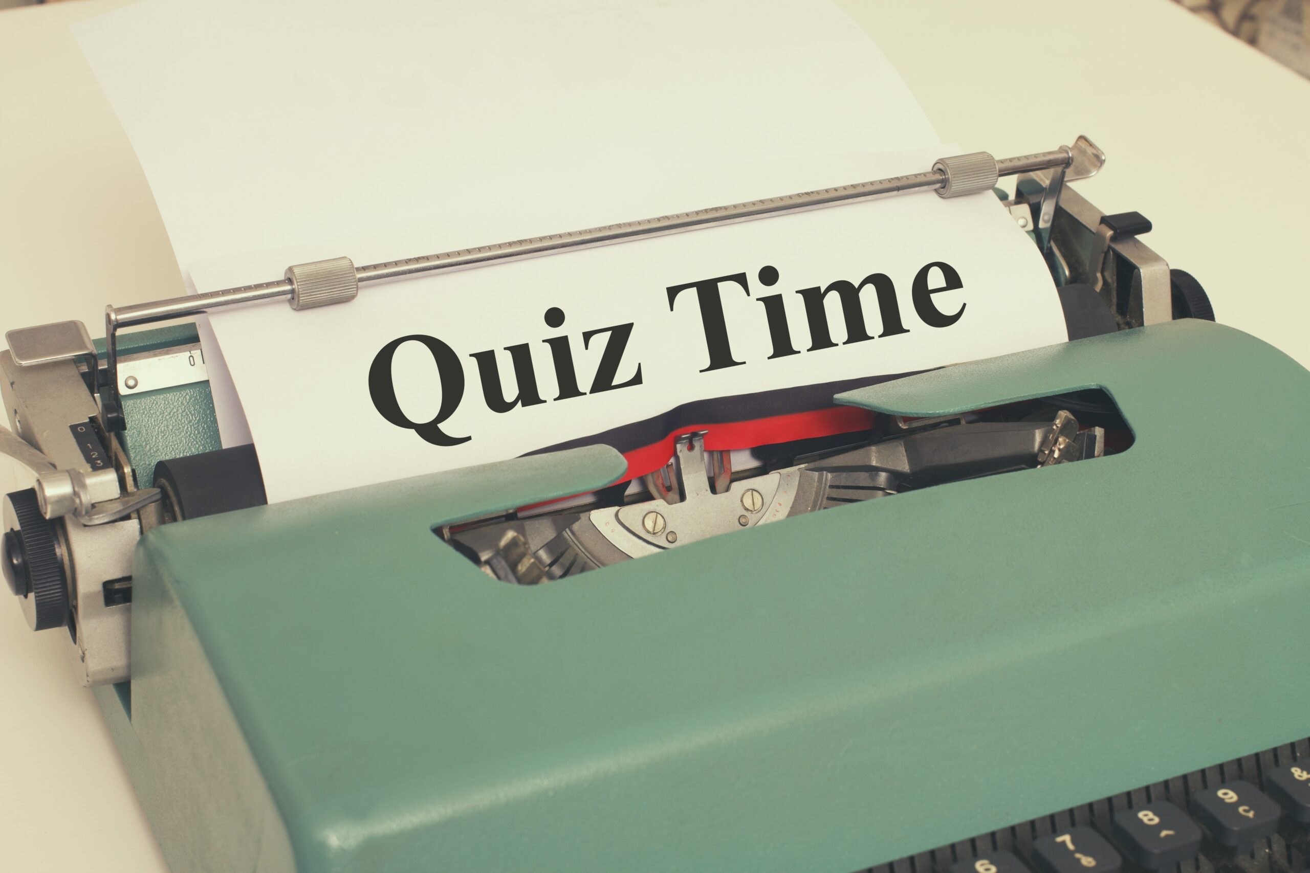 Starý psací stroj, ve kterém je papír s nápisem quiz time