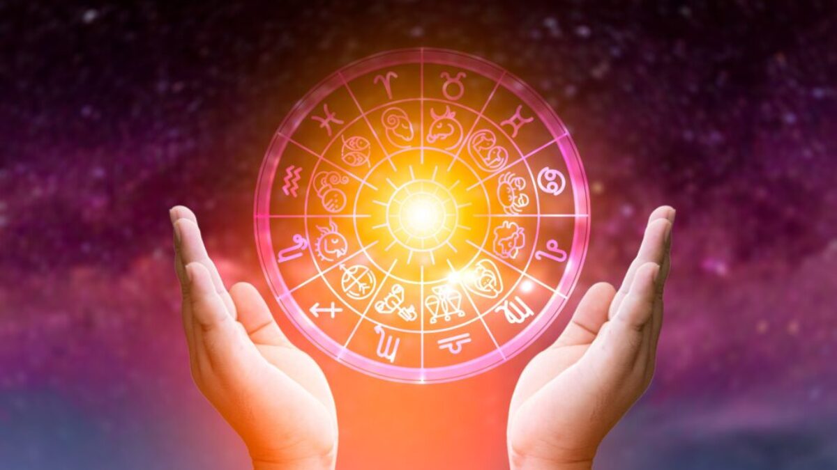 Astrologický kruh na barevném nebi, kolem dvě ruce