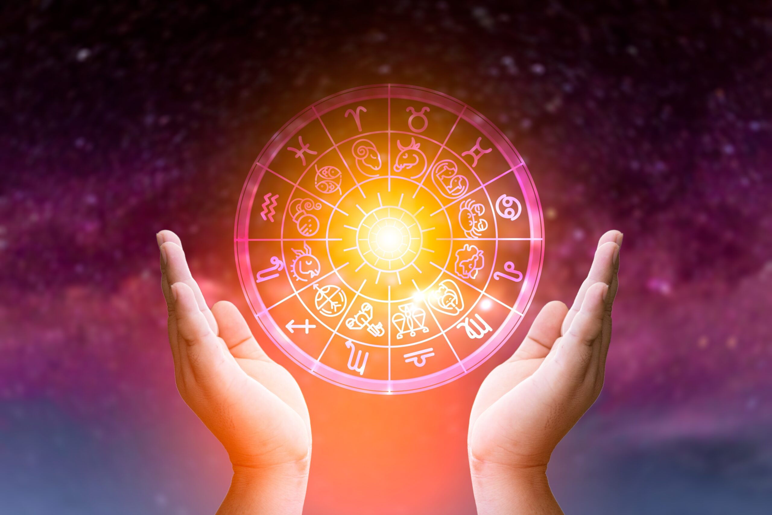Astrologický kruh na barevném nebi, kolem dvě ruce