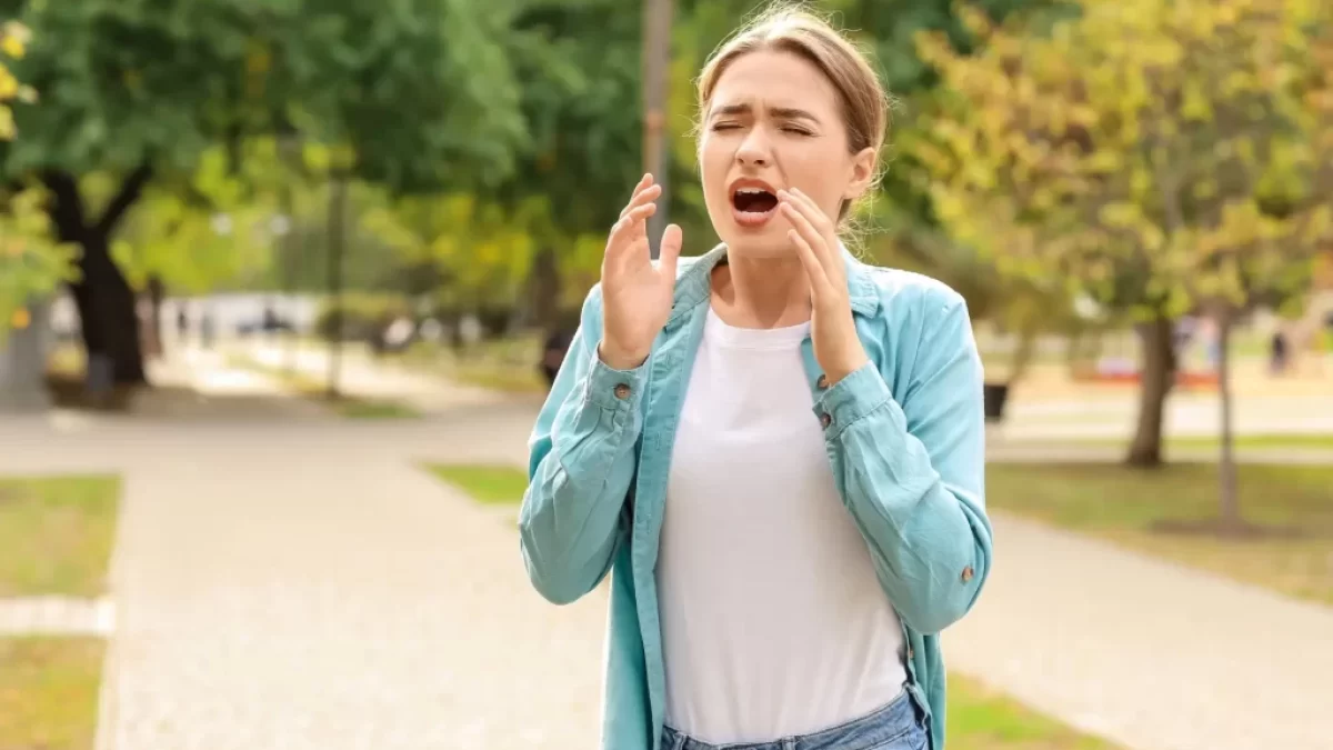 Žena kýchá venku