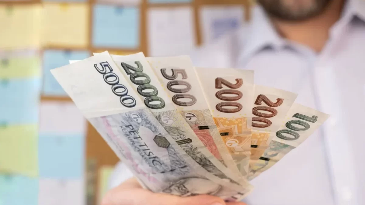 Muž dávající české bankovky