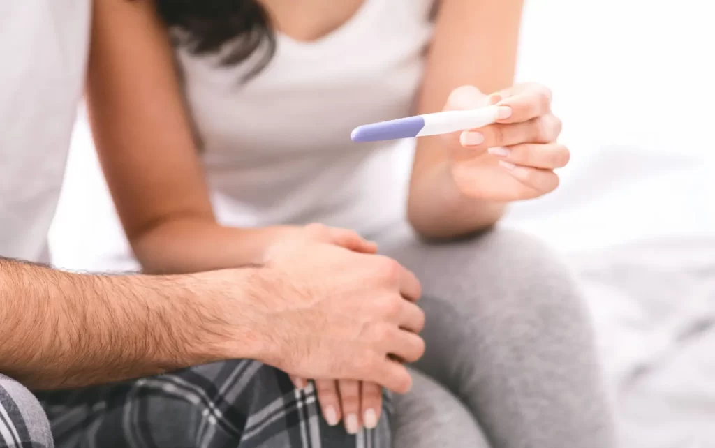 Žena ukazuje muži těhotenský test