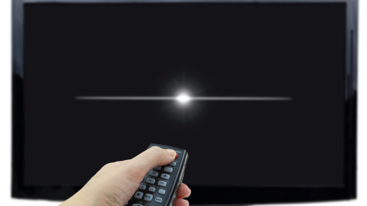 Ruka mířící ovladačem na TV a vypínající ji