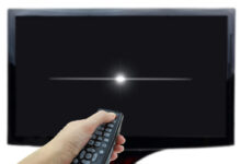 Ruka mířící ovladačem na TV a vypínající ji