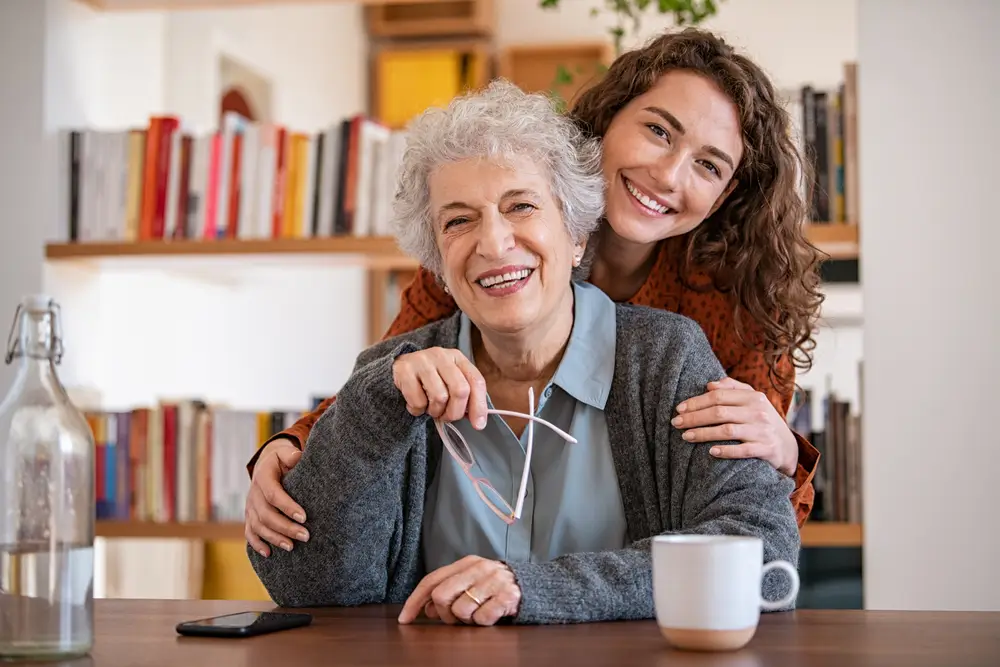 shutterstock_1926782009 - ByznysDeník Mladší žena drží za rameno a paži starší ženu.