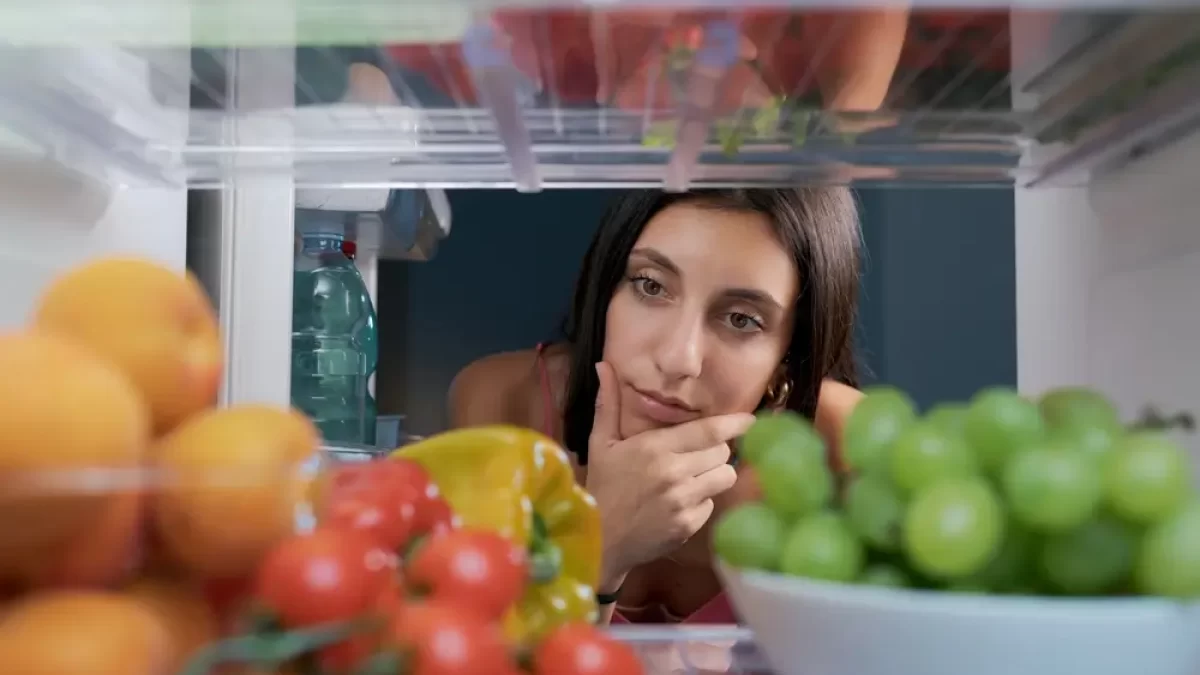 Žena se dívá do lednice.