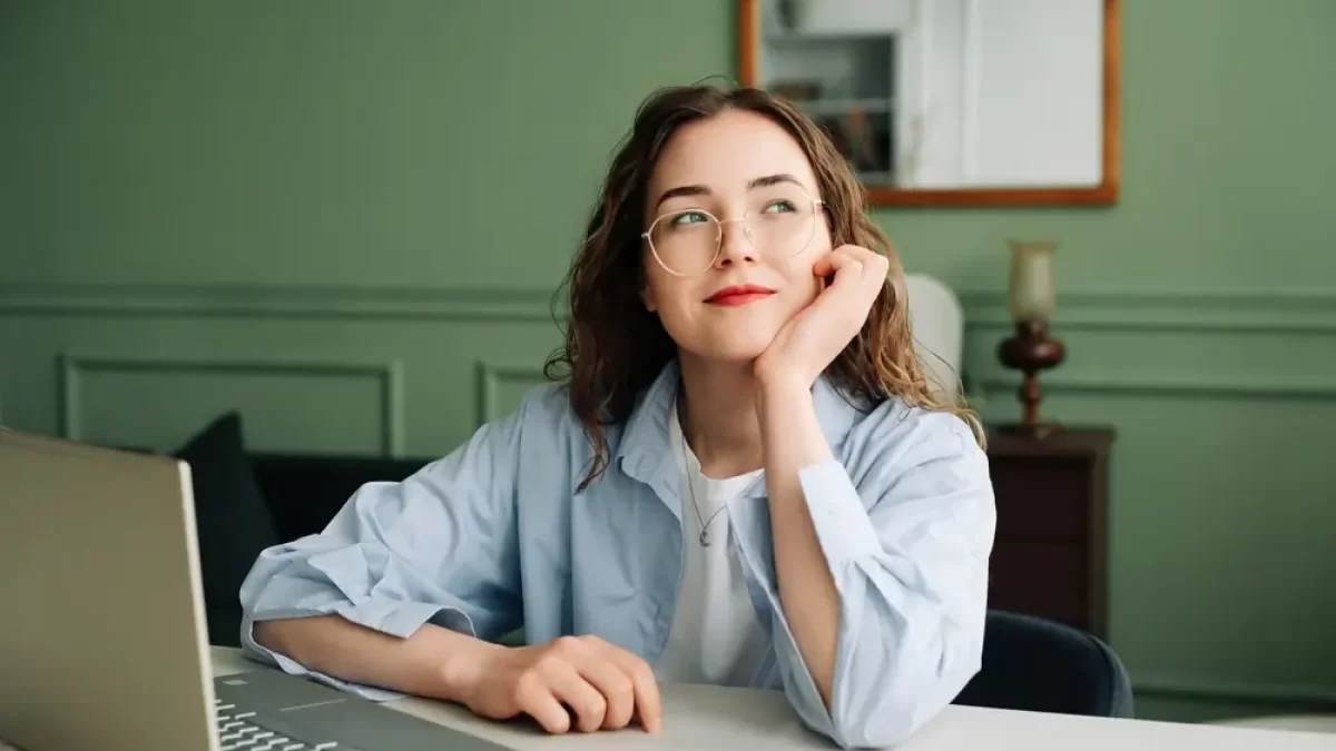 Žena zasněně hledí do prázdna.