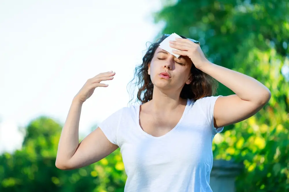 shutterstock_2337157479 - ByznysDeník Žena si otírá pot z čela.