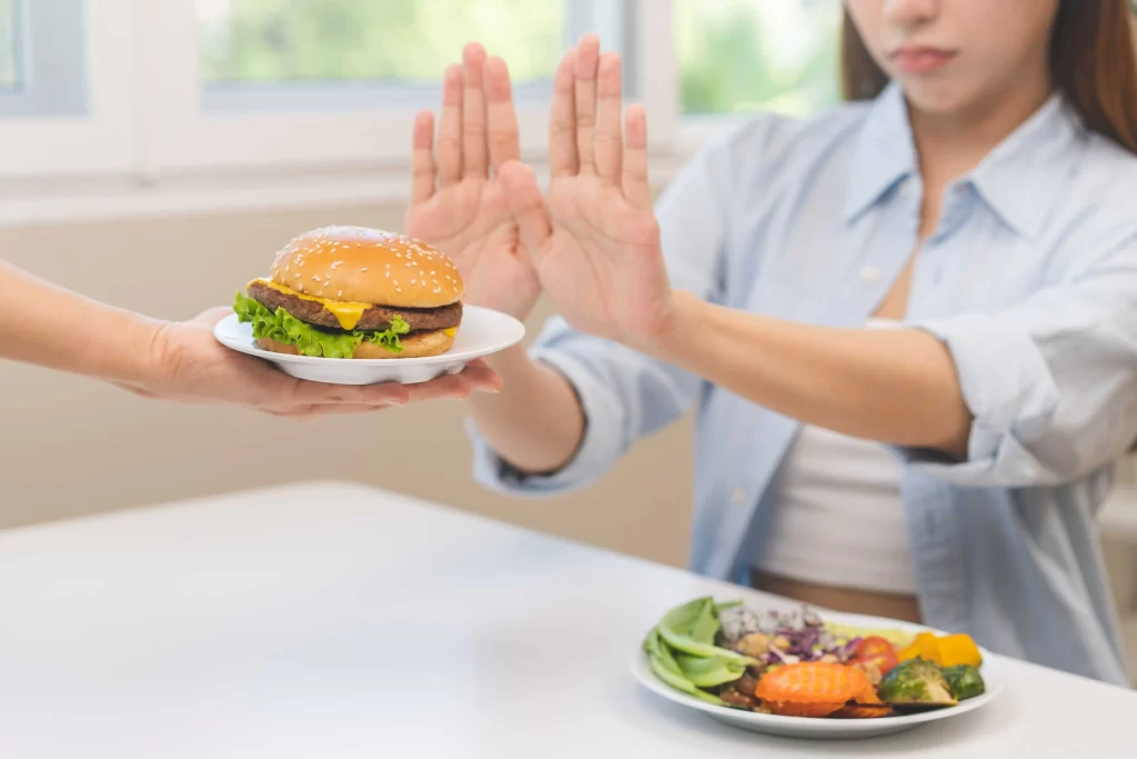 shutterstock_2397061483_optimized - ByznysDeník žena odmítá hamburger