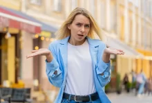 Žena rozpažuje dlaně na kameru.