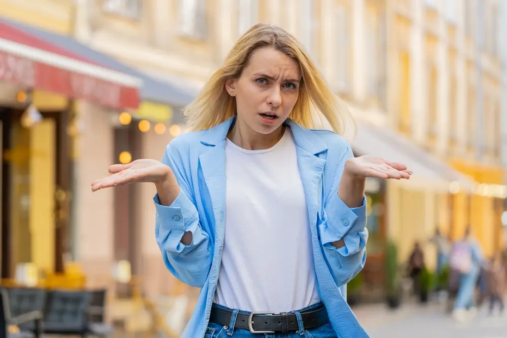 Žena rozpažuje dlaně na kameru.