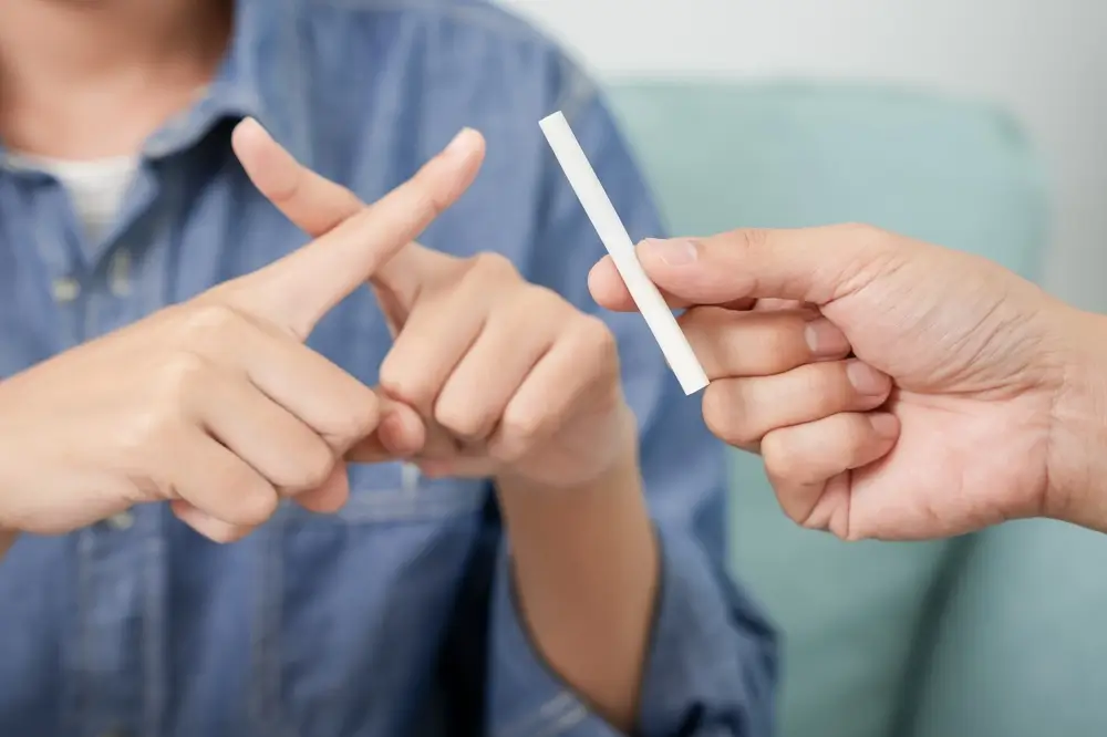 Muž odmítá nabízenou cigaretu. 