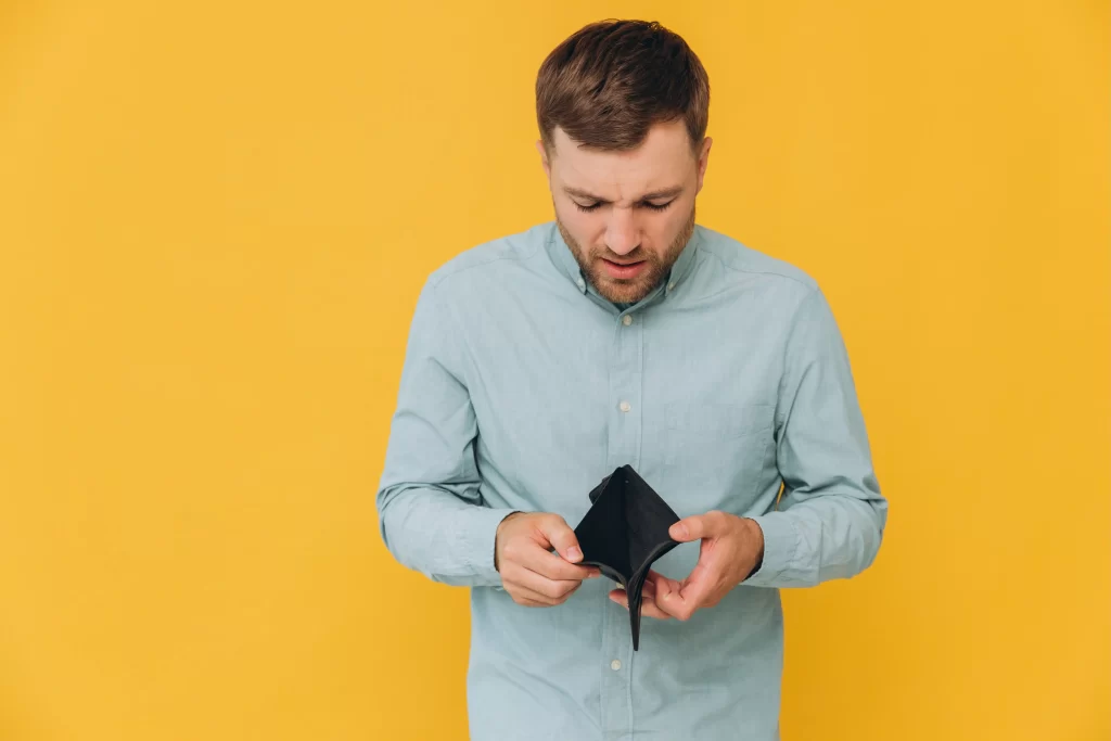 Jeho zaměstnání není příliš dobře finančně ohodnoceno. Zdroj: Shutterstock - ByznysDeník Muž dívající se do prázdné peněženky.