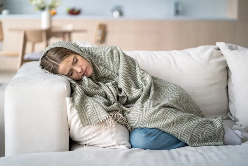 shutterstock_2527778329 - ByznysDeník Žena leží na gauči.