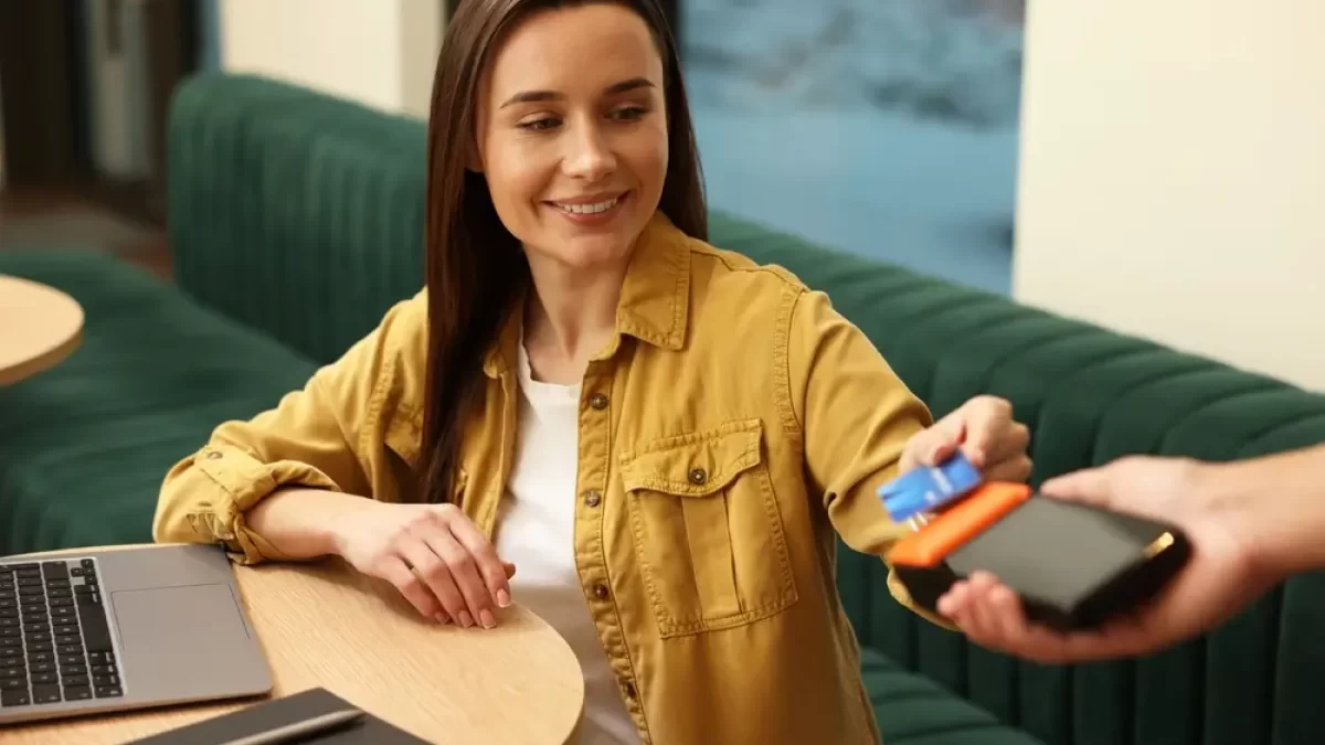 žena platí kartou v restauraci