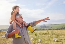 Dědeček nese na ramenou vnučku.