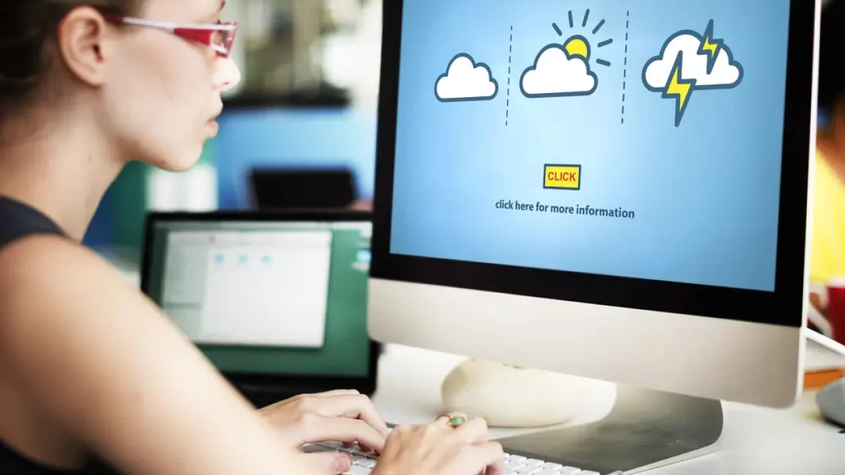 Žena sedí u PC, kde jsou symboly počasí.