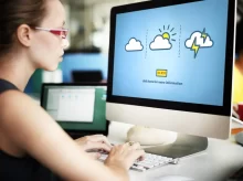 Žena sedí u PC, kde jsou symboly počasí.