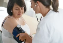 Doktorka měří ženě tlak.