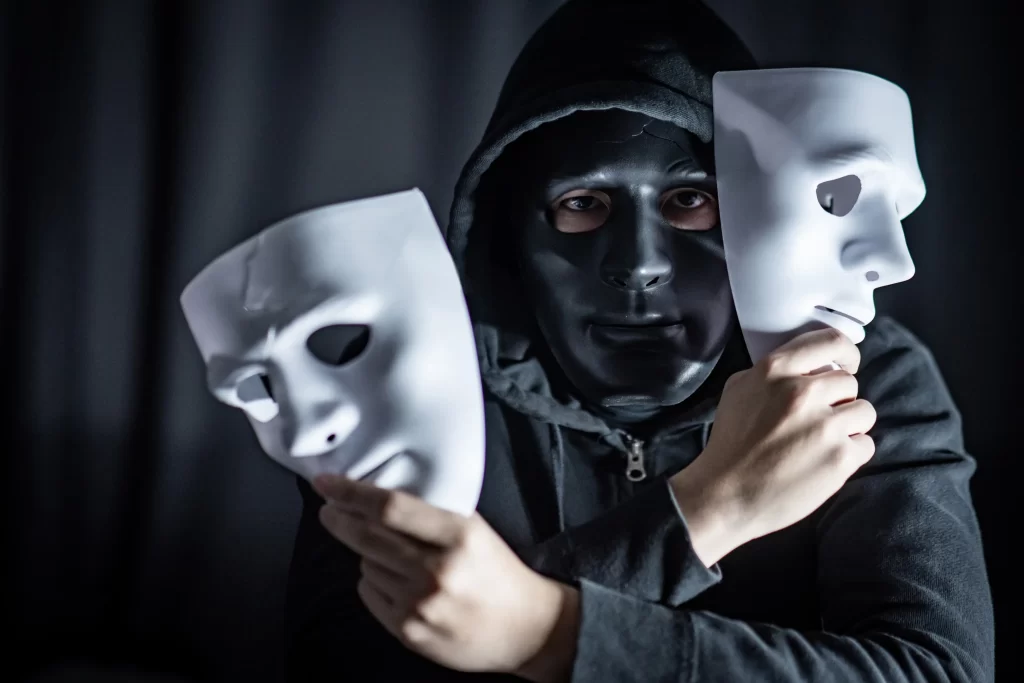 Někteří na sobě mají masku a jednají jinak, než jací skutečně jsou. Zdroj: Shutterstock - ByznysDeník Muž v černé masce a dvěma maskami v ruce.