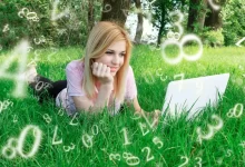 Žena leží v trávě s notebookem. Okolo ní jsou čísla.