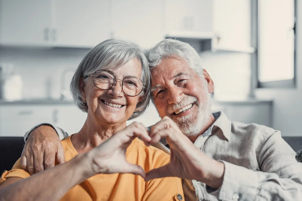Ne každý z nás je dobrosrdečný. Zdroj: Shutterstock - ByznysDeník Starší muž se ženou dělající srdíčko.