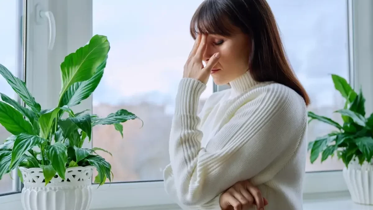 Žena u okna se chytá za hlavu.