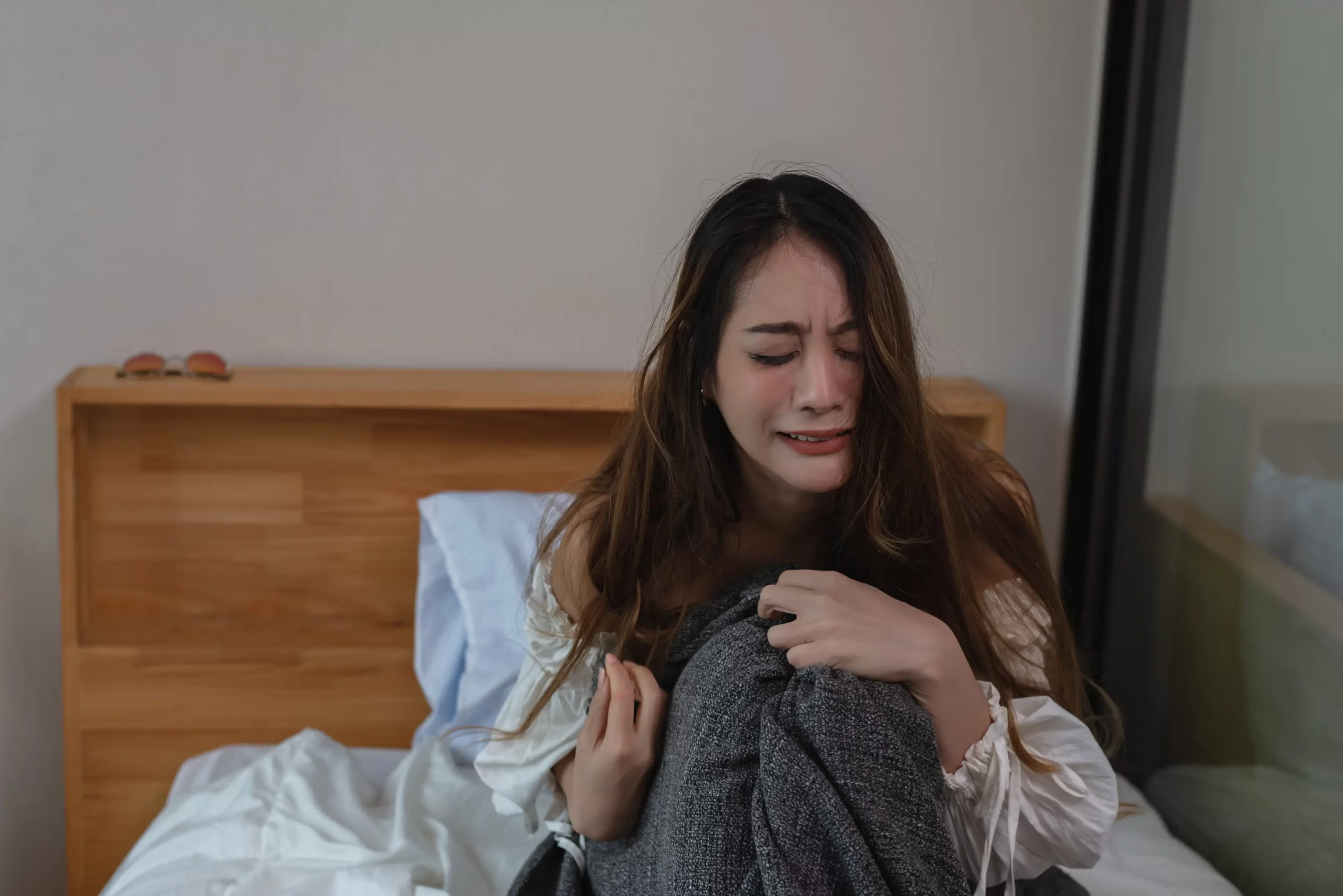 Plačící žena na posteli.