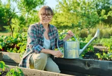 Žena s konví zalévající zahradu.