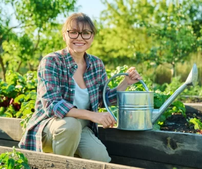 Žena s konví zalévající zahradu.