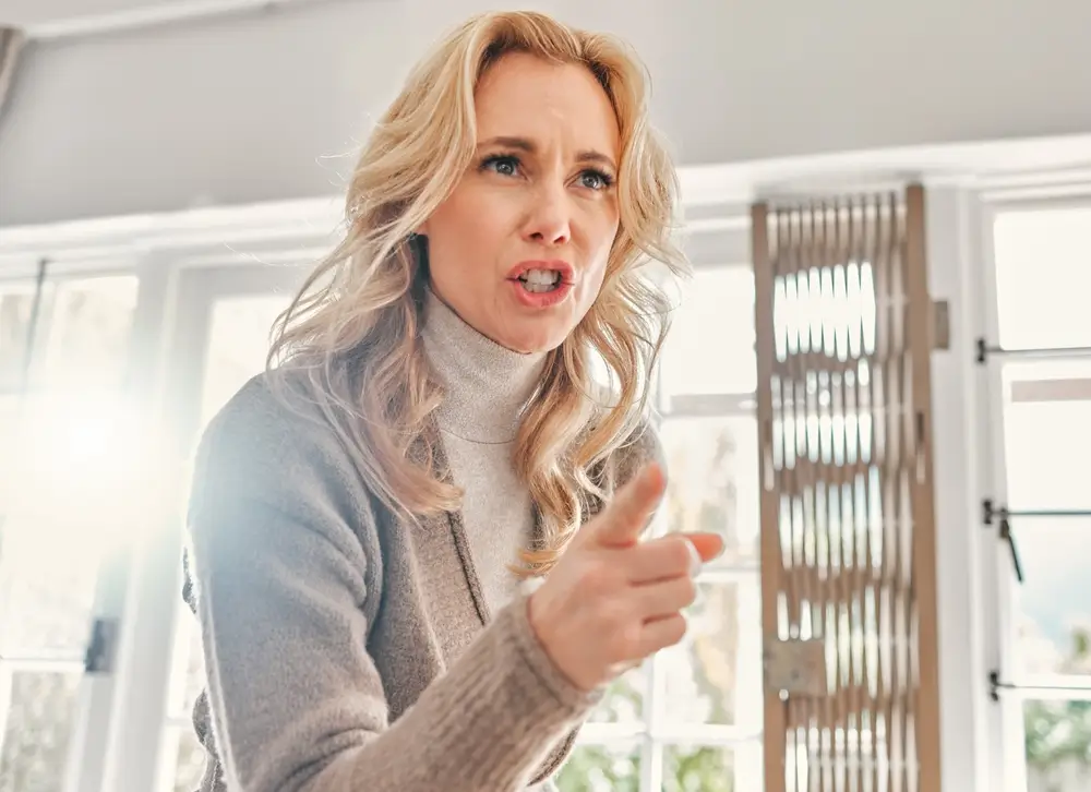 shutterstock_2494845841 - ByznysDeník Žena ukazuje na někoho prstem a má naštvaný výraz v obličeji.