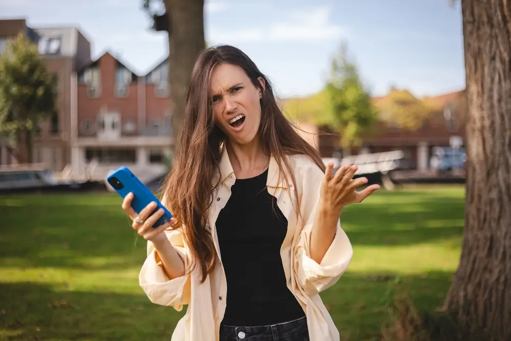 shutterstock_2540812801 - ByznysDeník Naštvaná žena držící telefon.