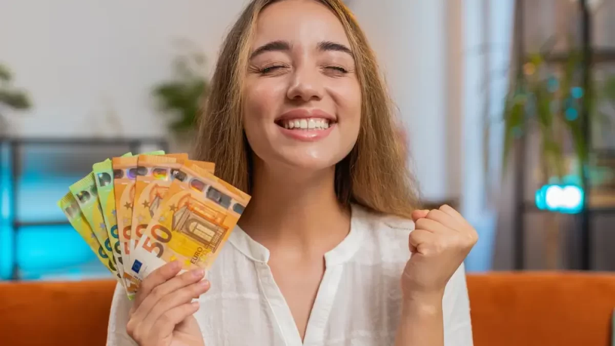 Žena s bankovkami v ruce se raduje.