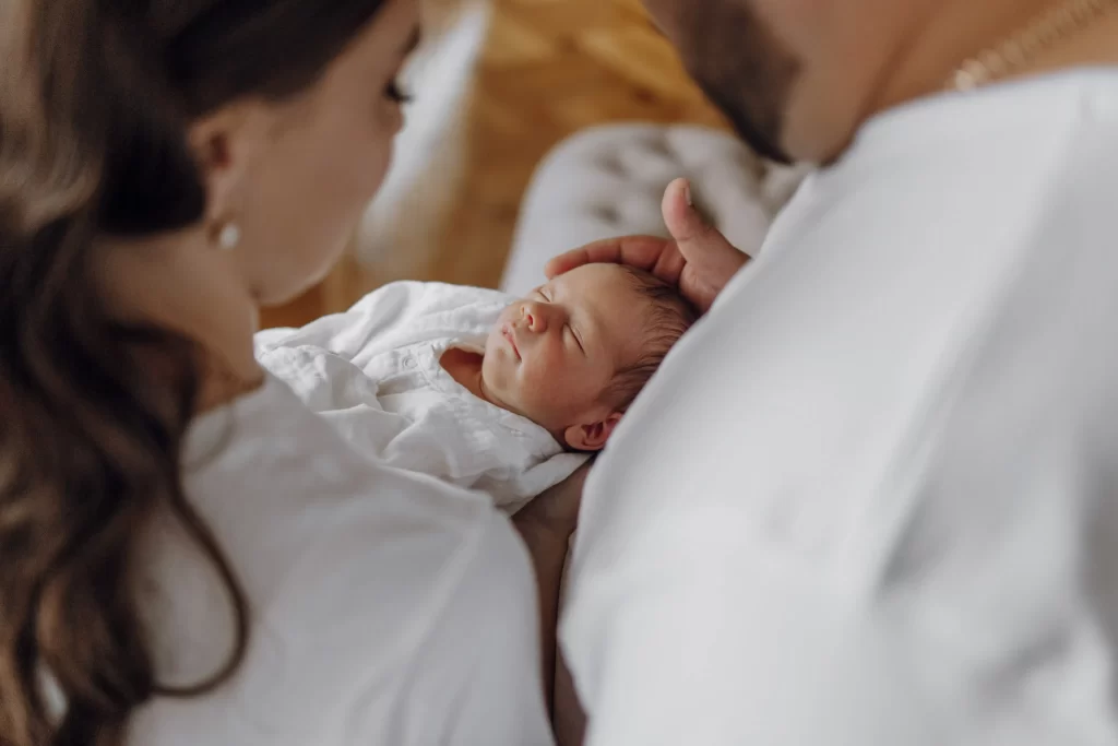 Již narozené miminko má nějaké vlastnosti podle genetiky. Zdroj: Shutterstock - ByznysDeník Žena držící miminko v peřince.