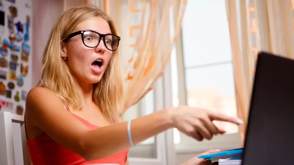 Žena se dívá do PC a je zhrozena.