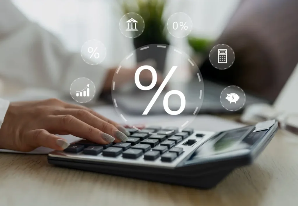 Ruka ťuká na kalkulačku s digitálními ikonami znázorňujícími procenta a finance