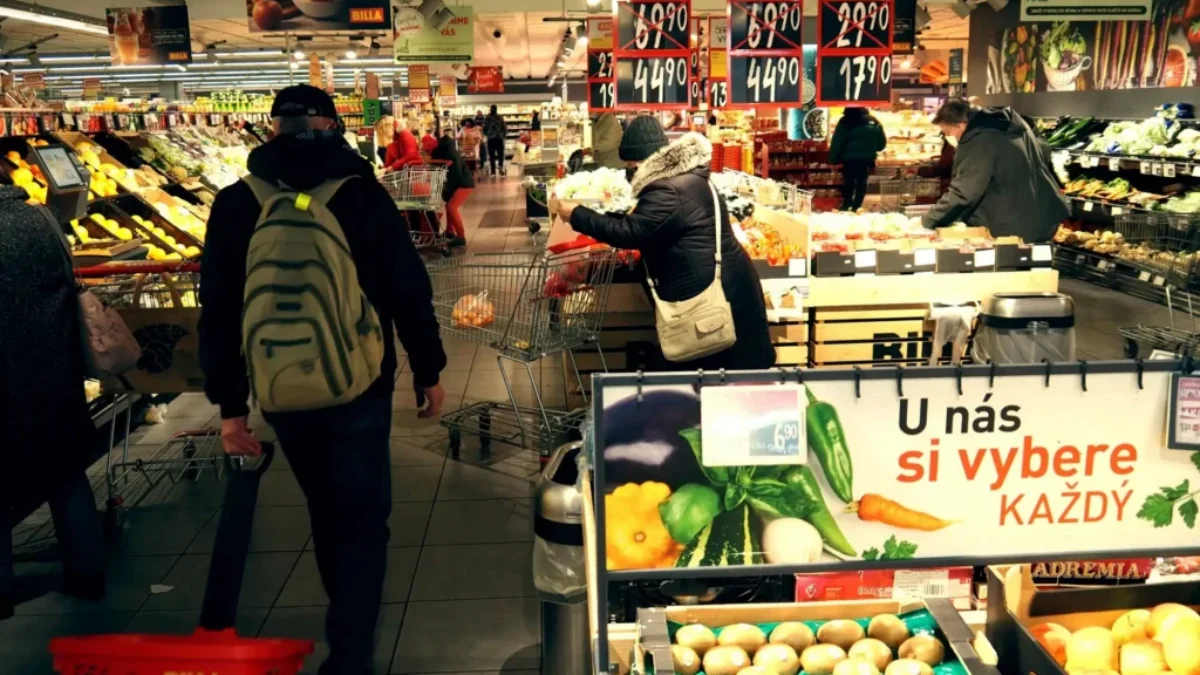 Uvnitř supermarketu prochází tákazníci oddělením ovoce a zeleniny