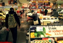Uvnitř supermarketu prochází tákazníci oddělením ovoce a zeleniny