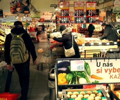 Uvnitř supermarketu prochází tákazníci oddělením ovoce a zeleniny