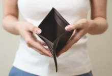 Žena drží v ruce prázdnou peněženku