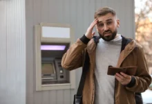 Muž u bankomatu s prázdnou peněženkou