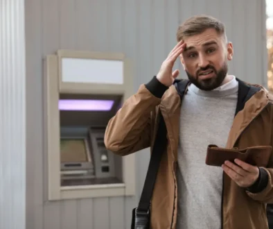 Muž u bankomatu s prázdnou peněženkou